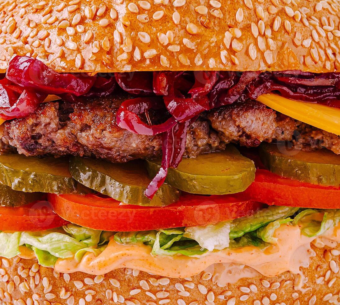 Juicy burger with fresh toppings and sesame bun on wooden table photo