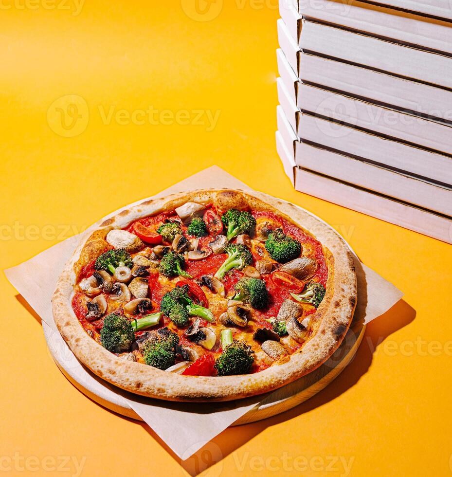 Freshly baked veggie pizza surrounded by empty boxes photo