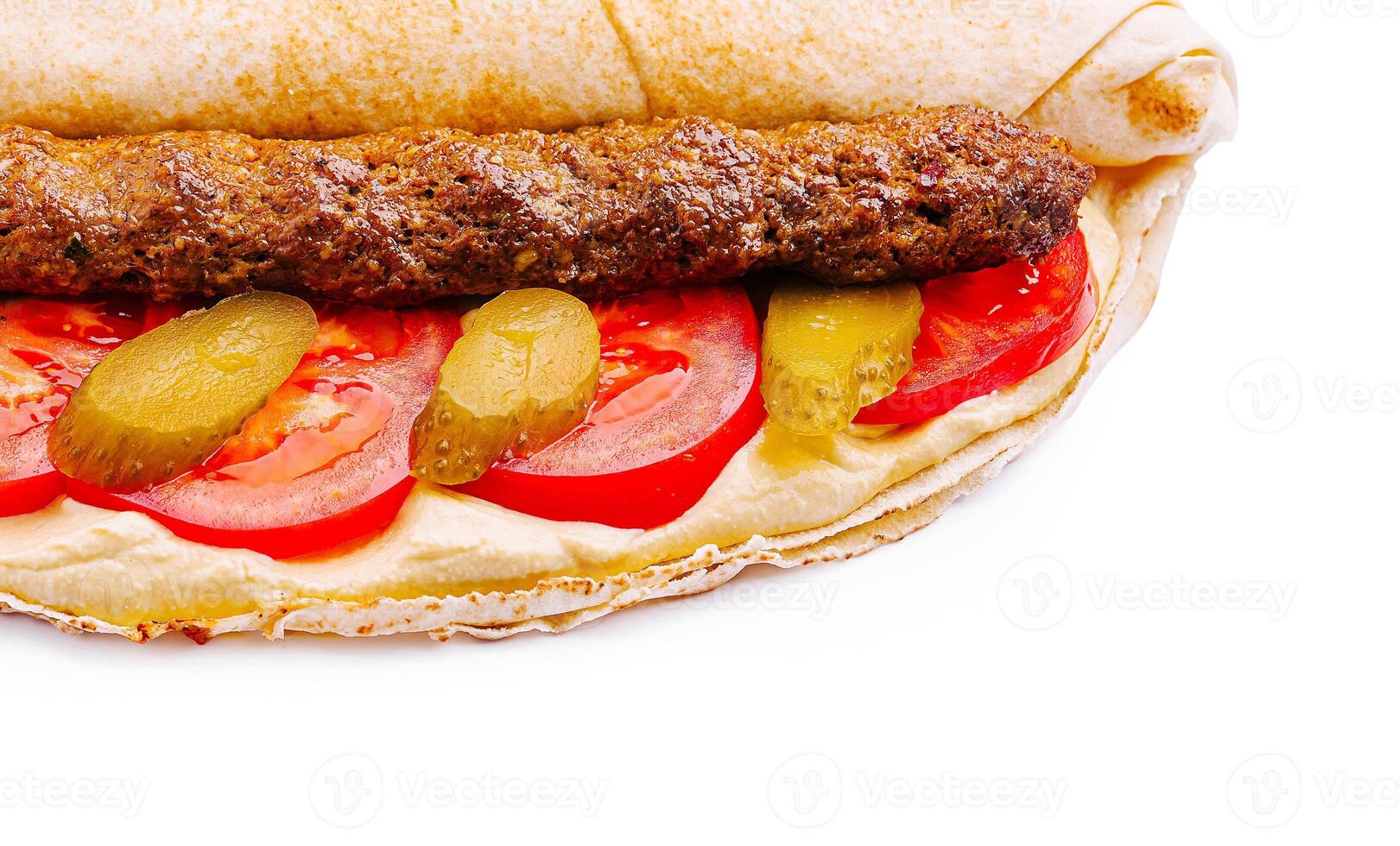 Delicious wrap filled with meat, fresh vegetables, and sauce photo