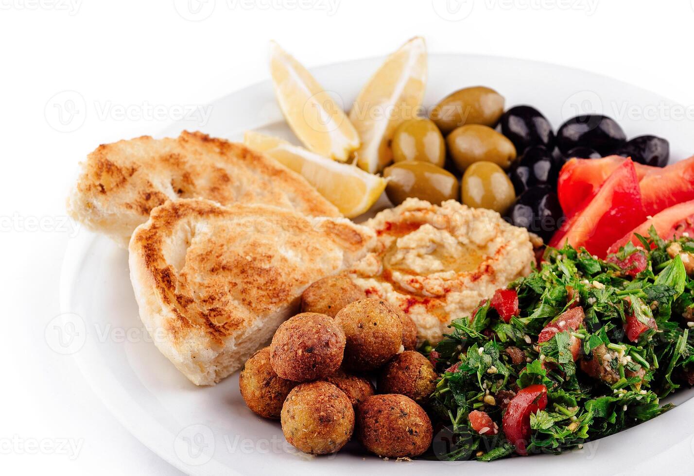 Plate presenting a colorful and tasty middle eastern mezze platter with various dips and salads closeup photo