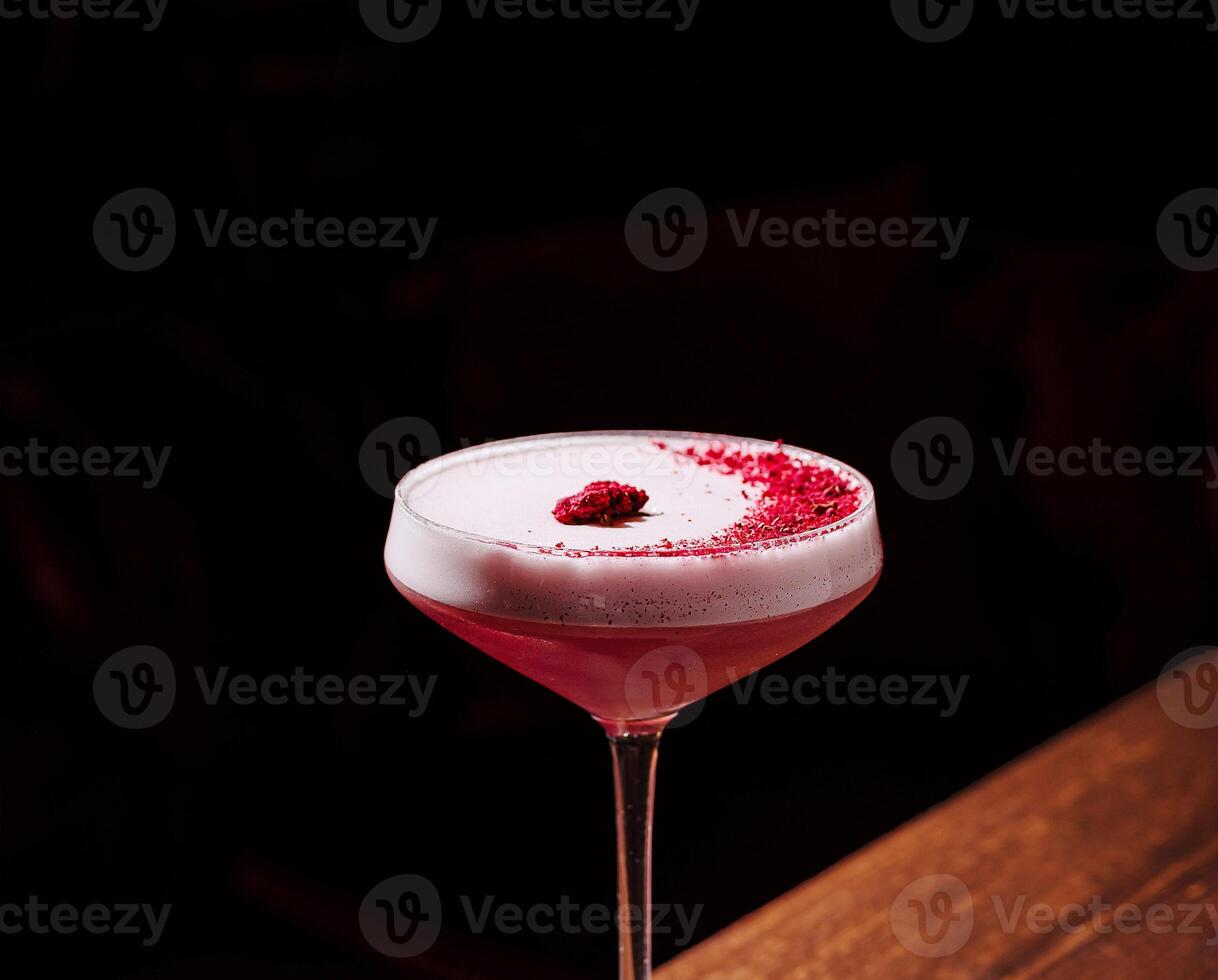 Raspberry cocktail in an elegant glass under soft lighting photo