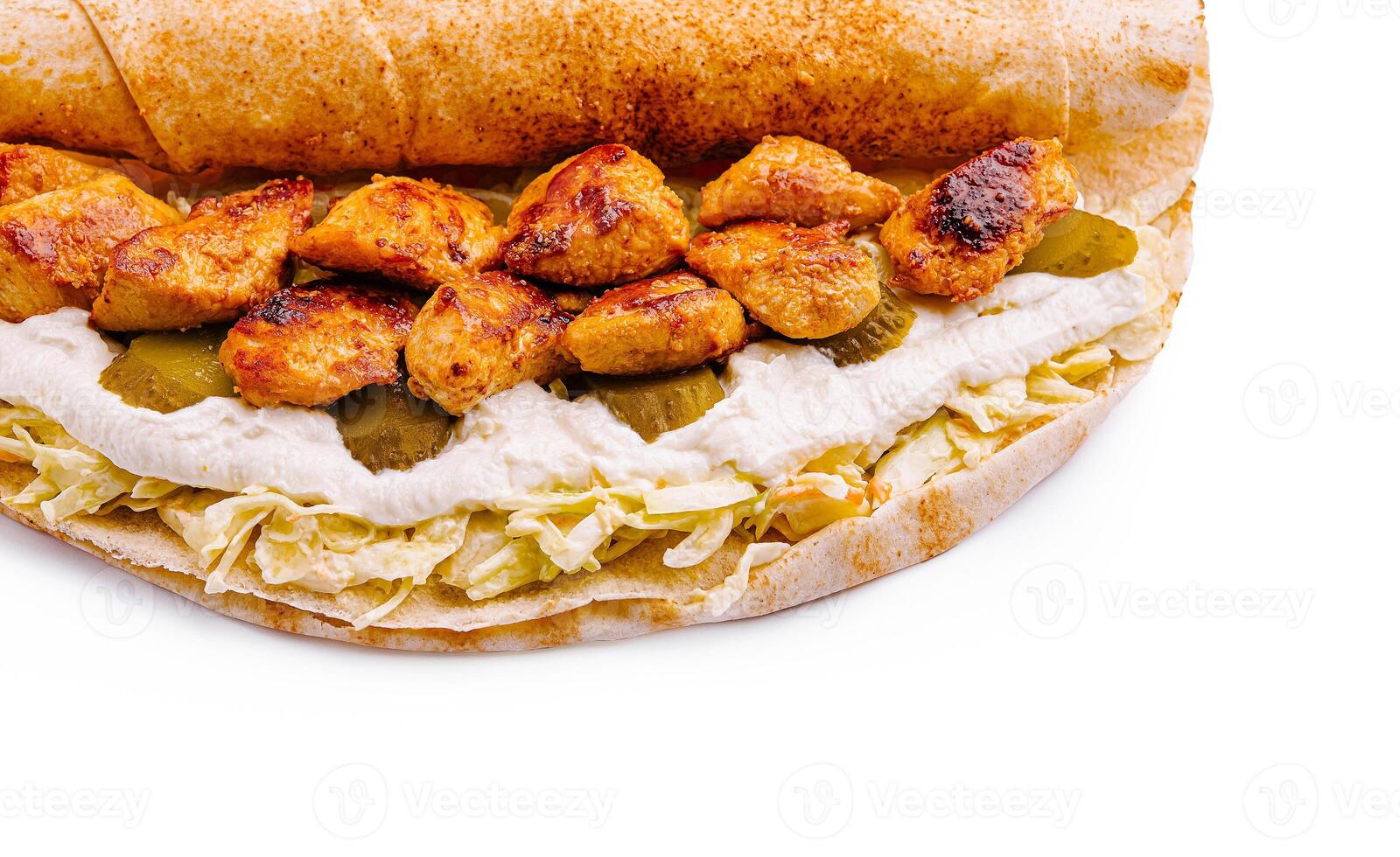 Grilled chicken wrap with creamy sauce and pickles on flatbread photo