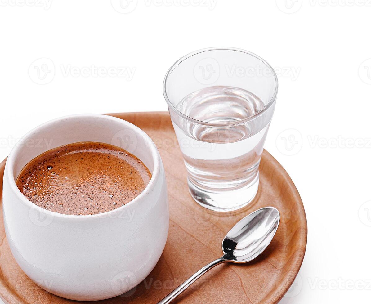 Warm coffee served with a glass of water on a wooden tray photo