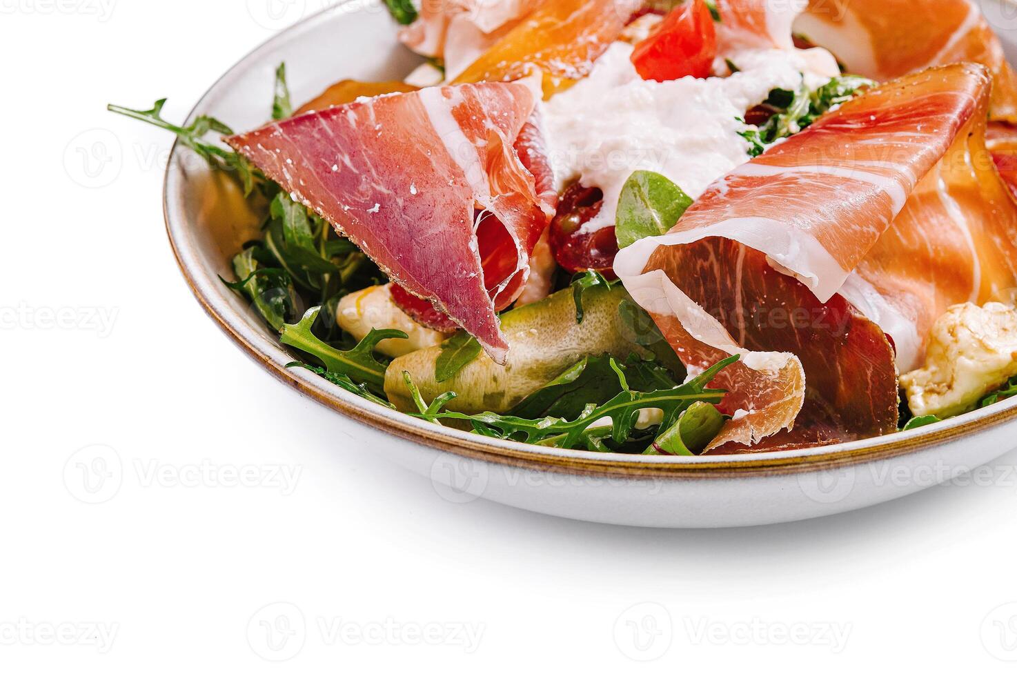 Fresh prosciutto and arugula salad bowl close up photo