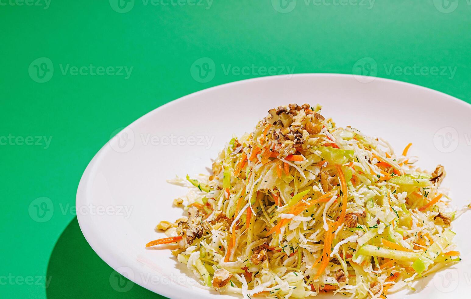 Fresh vegetable salad with walnuts on a green background photo