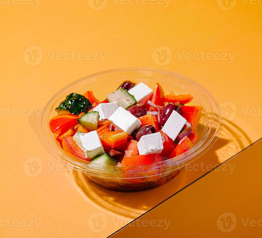 Fresh salad bowl with colorful vegetables and cheese cubes photo