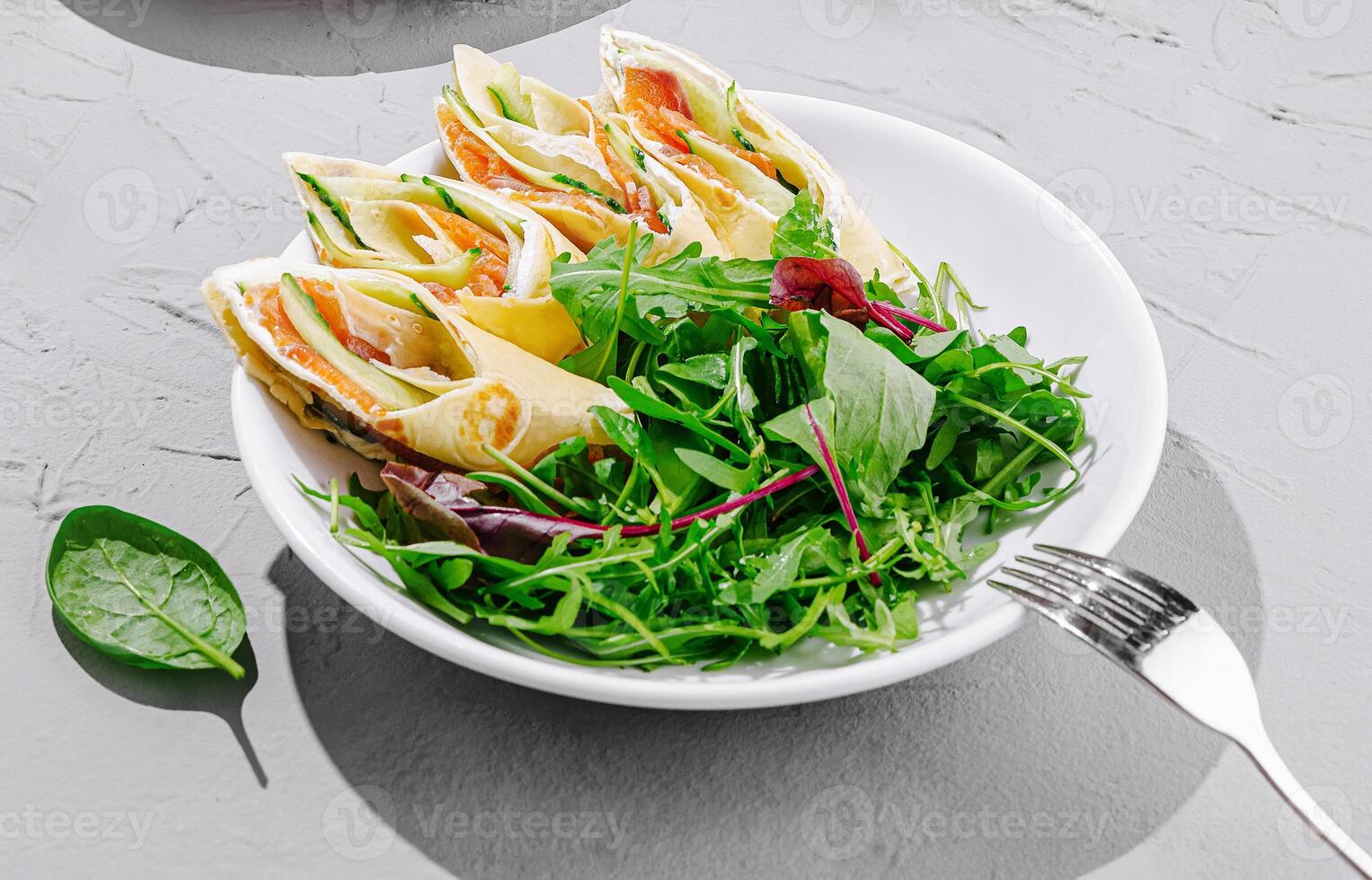 Fresh wrap rolls with salad served on a gray table photo