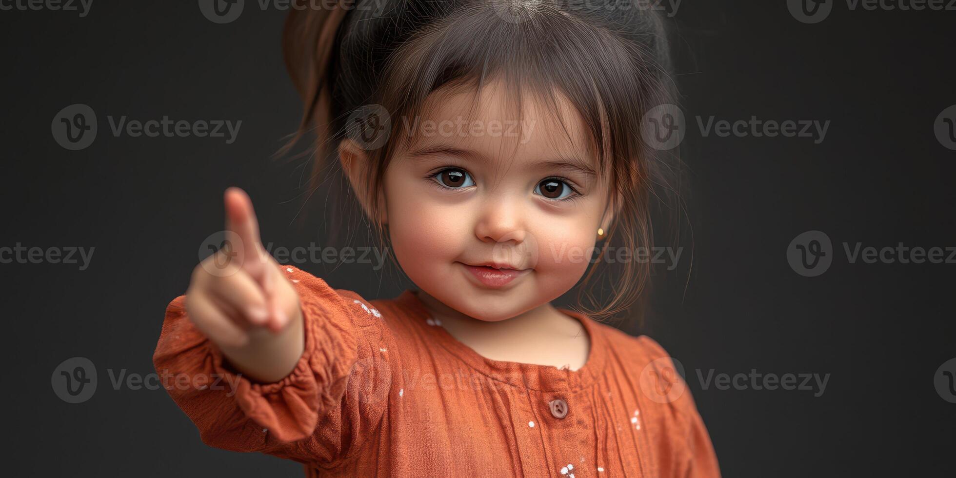 Young girl with playful expression gestures while wearing an orange dress in a cozy indoor setting during afternoon light photo