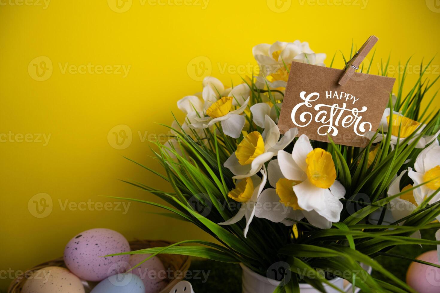 Inscription card Happy Easter on daffodil flowers Colorful eggs yellow background photo