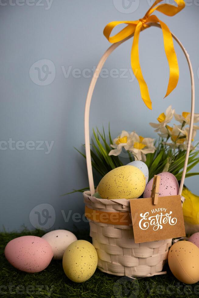 Vertical scene of basket full with eggs and yellow daffodil flowers photo
