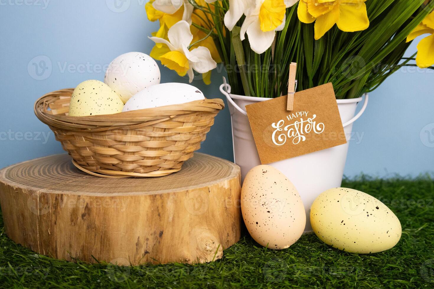Happy Easter inscription card in daffodil flowers and colorful eggs close up photo