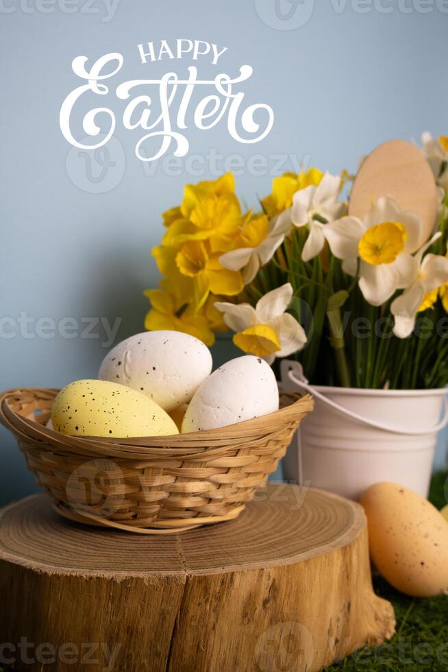Vertical Easter card with colorful eggs close up and daffodil flowers in a bucket in background photo