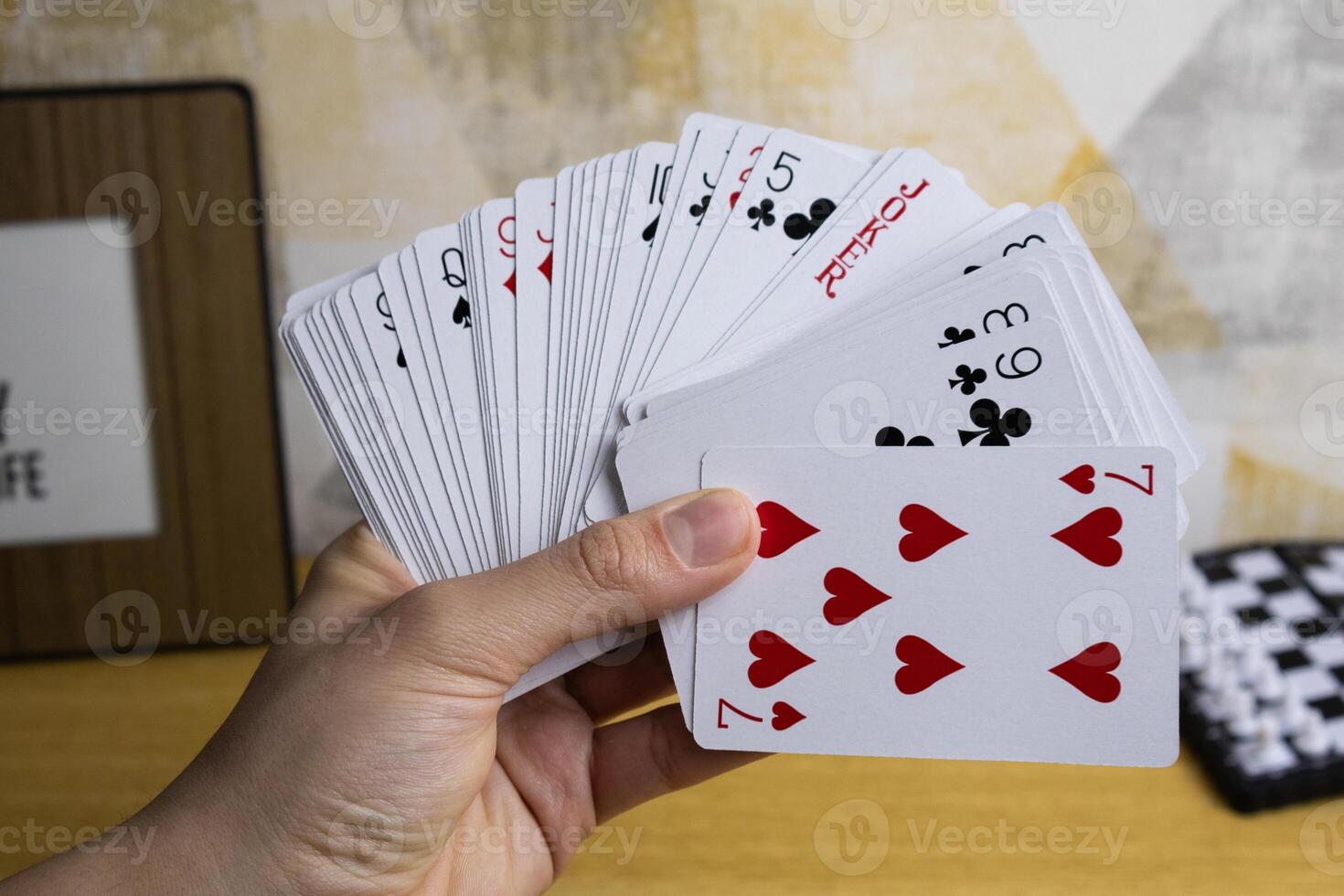One hand holds many playing cards photo