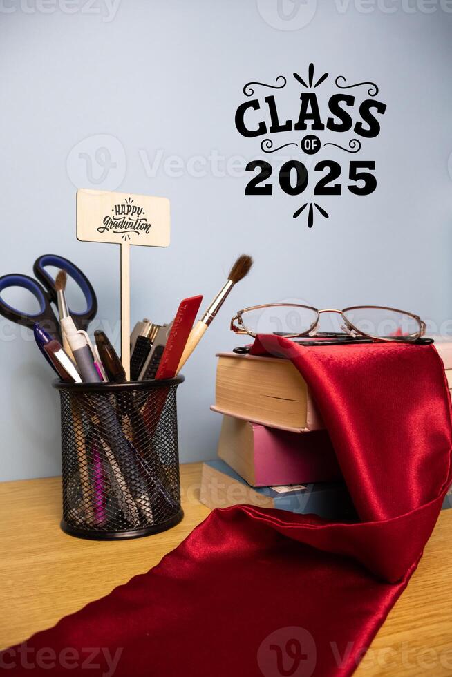 Vertical graduation background with pen holder academic stole on a stack of books Class of 2025 photo