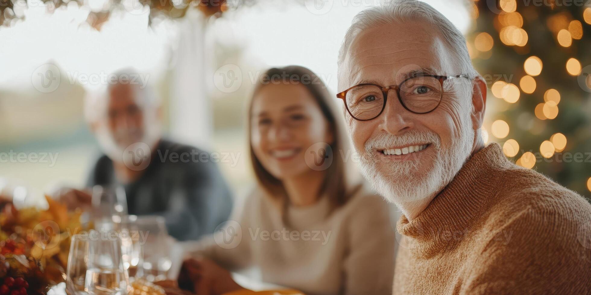 A man with glasses and a sweater smiles at the camera photo