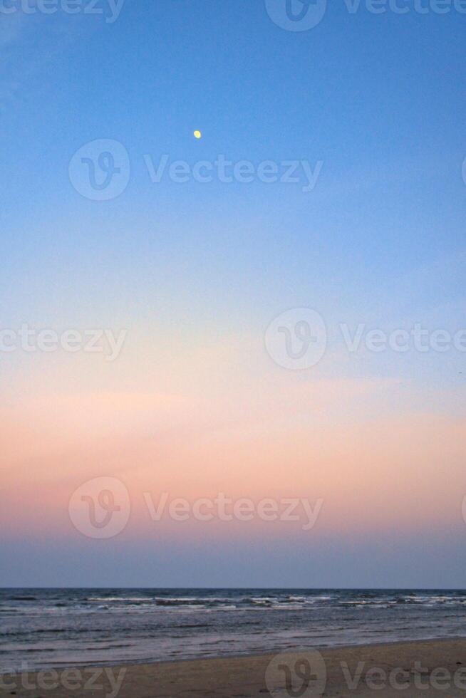 Moon in the sky in front of the beach on the island of Usedom on the Baltic Sea. photo