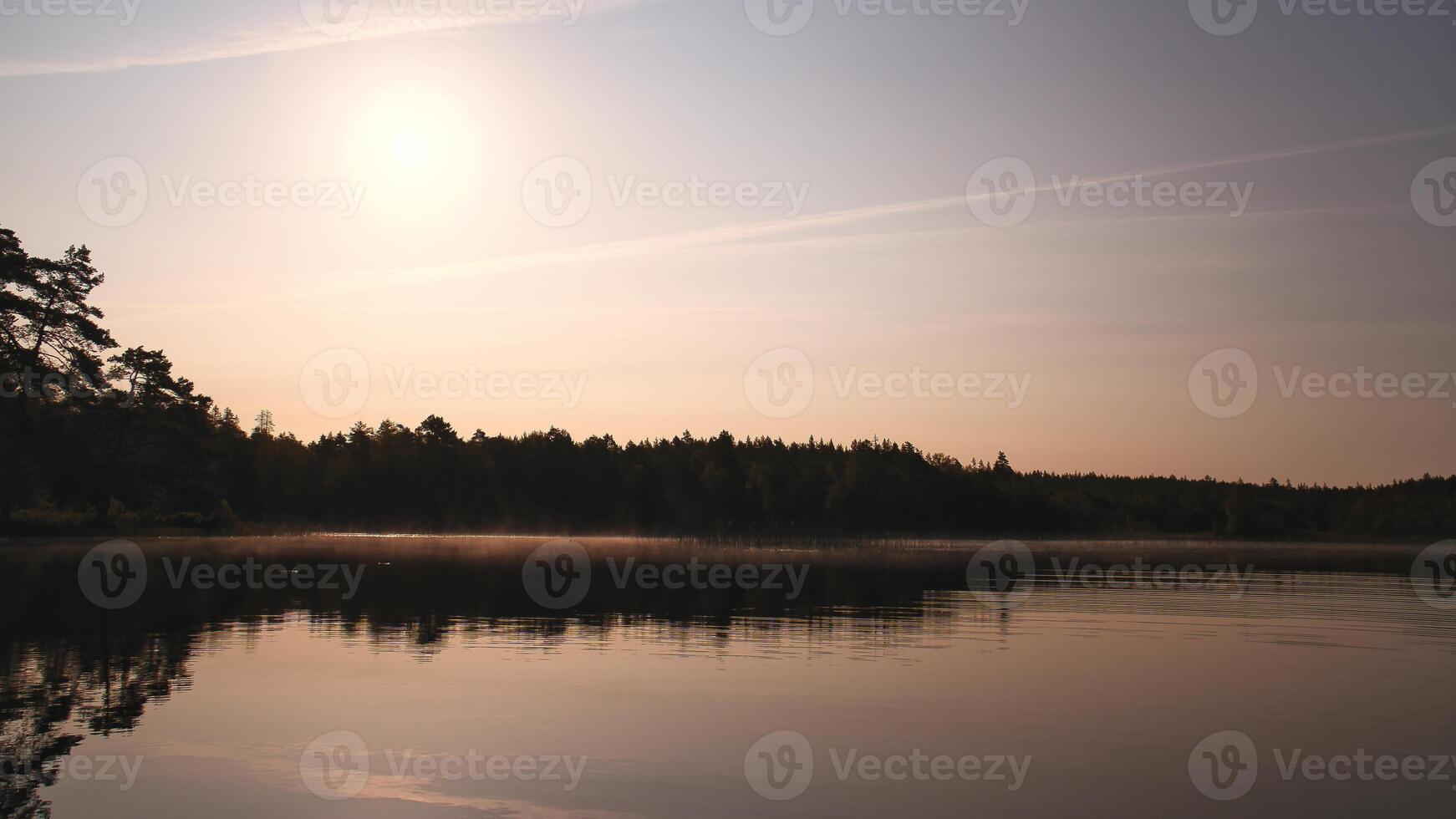Lake in Sweden, mirror-smooth water with romantic light and trees on the shore. photo