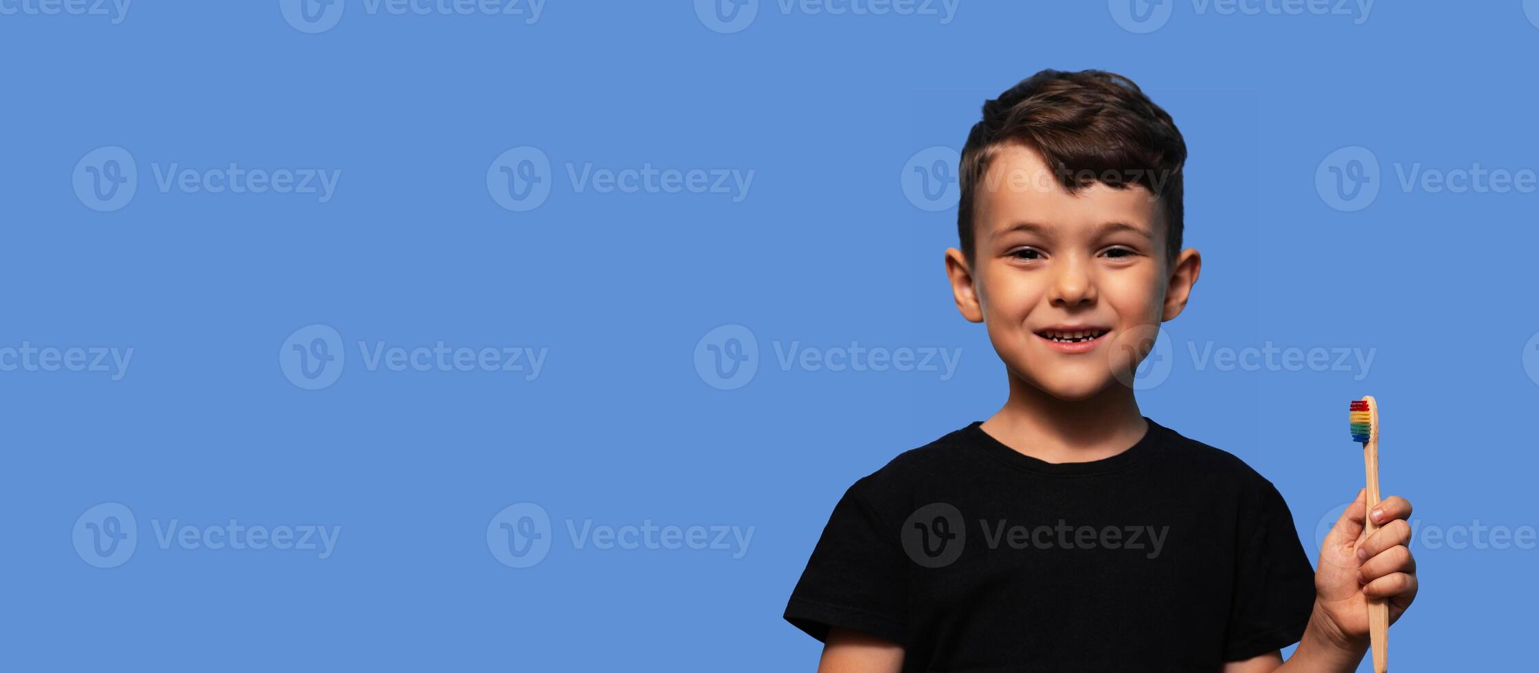 A cute boy with no front teeth. With a toothbrush in hand. Dental replacement and hygiene. Close-up. a place to copy photo