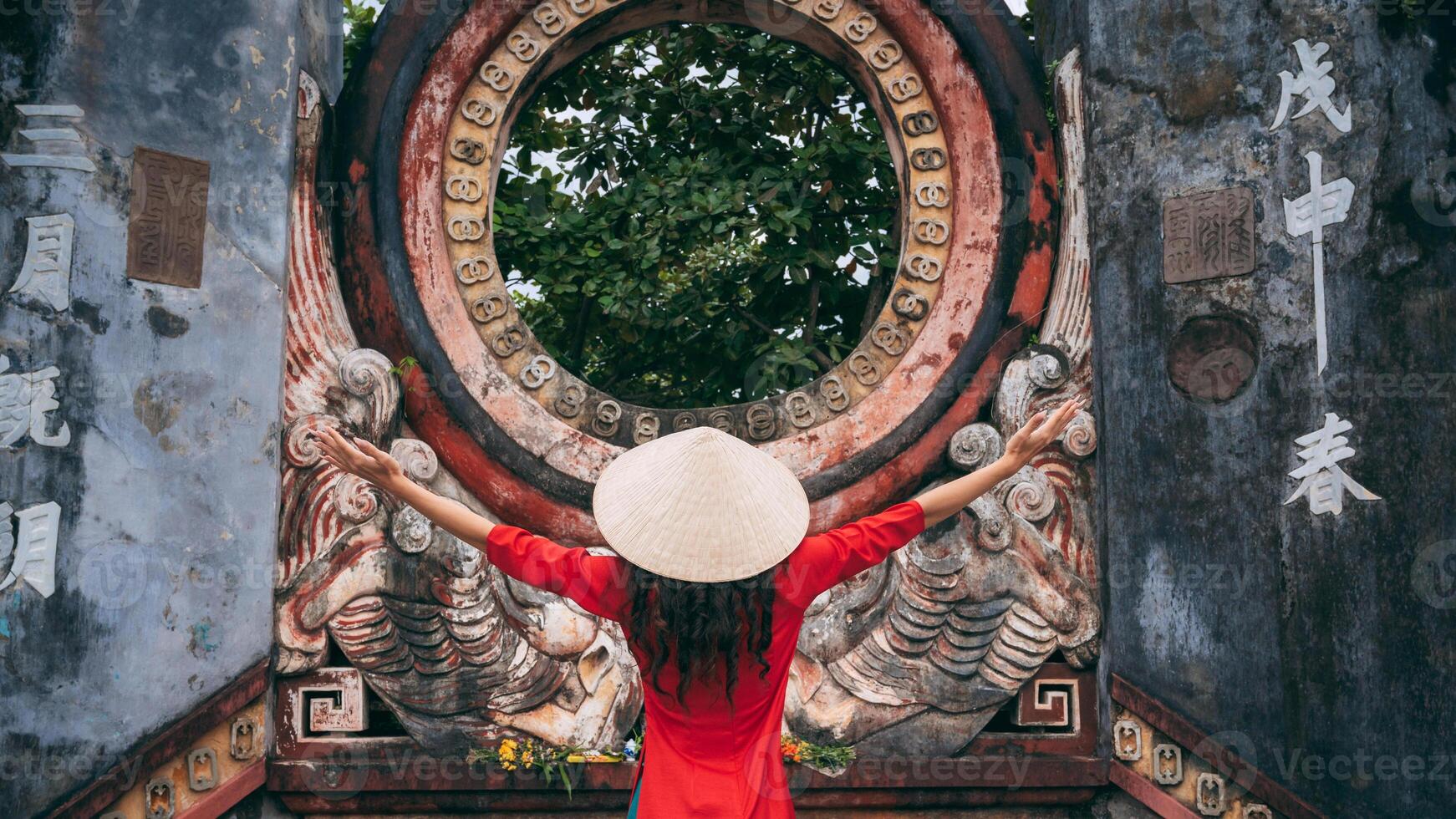 Young woman in red dress praying at Buddhist temple during Spring Festival, back view photo