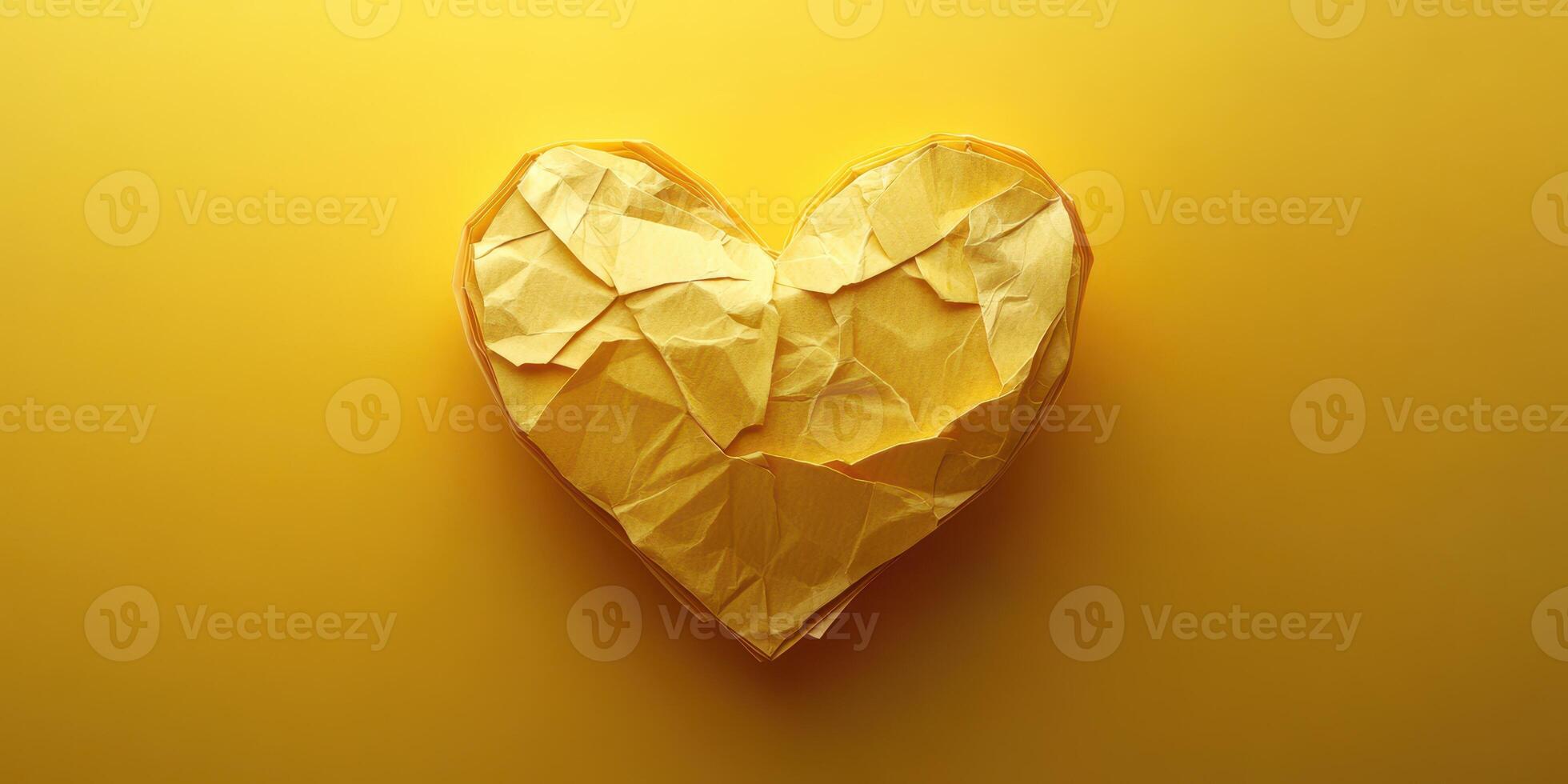 Crumpled yellow paper heart on vibrant yellow background creates a striking visual representation of love and creativity photo