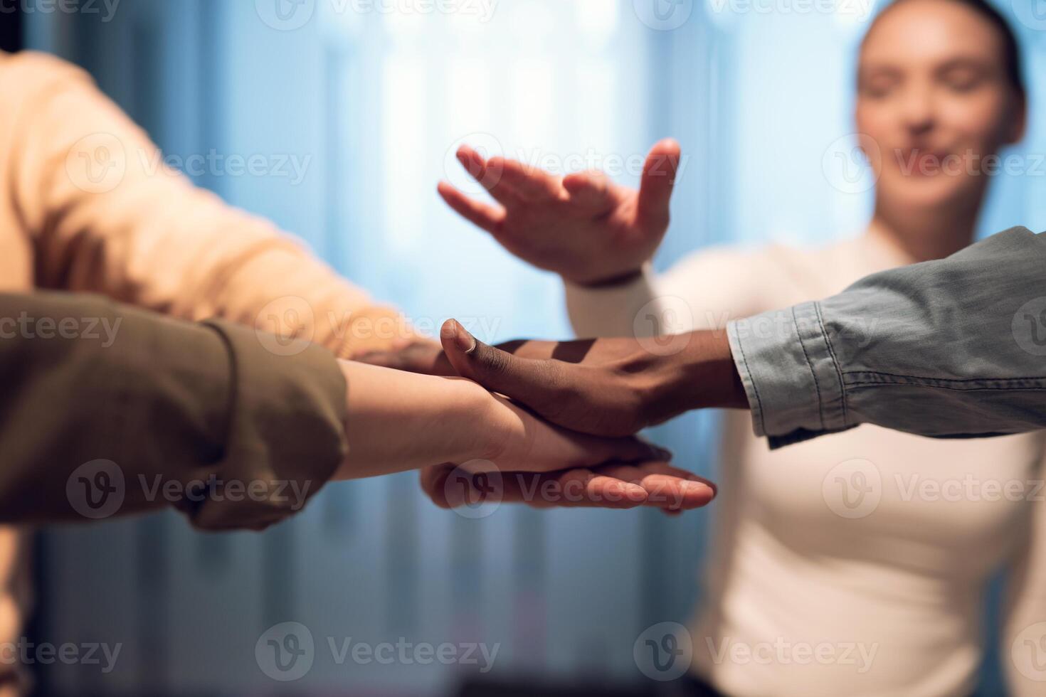 Business professionals stacking hands in support of collaboration, inclusion, and equality in the office. The workplace community huddles together for solidarity, cooperation, and team building. photo