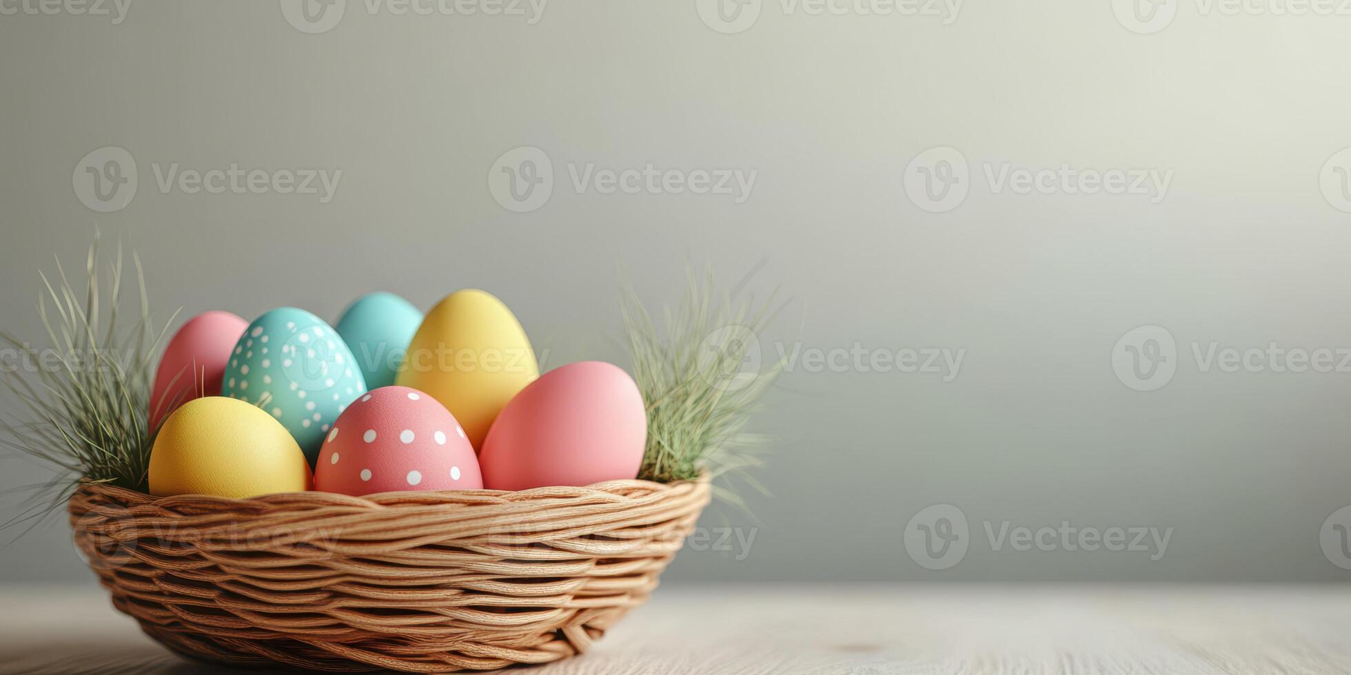 Colorful Easter eggs arranged in a woven basket surrounded by decorative grass on a light background photo
