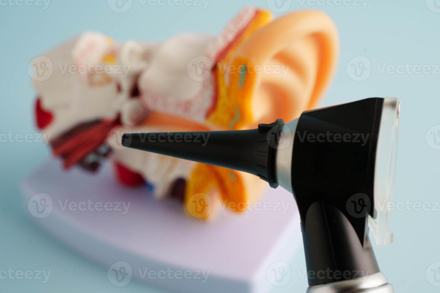 Otoscope with ear model for otolaryngologist or ENT physician doctor examining senior patient ear, hearing loss pr photo