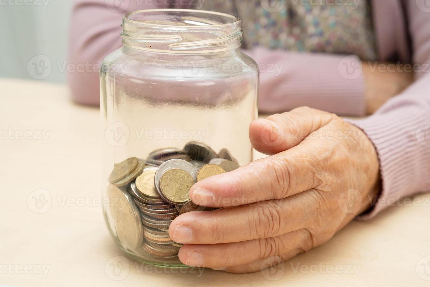 Retired Asian elderly woman counting coins money and worry about monthly expenses and treatm photo