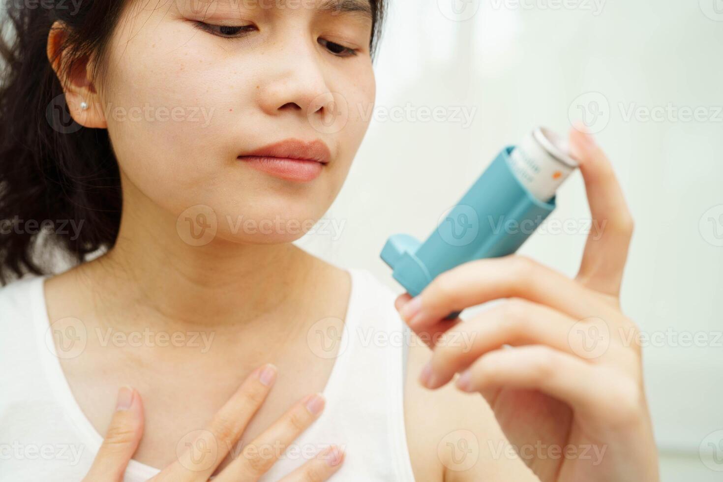 Asthma and chronic obstructive pulmonary disease COPD, Asian teenage using metered dose inhaler MDI. photo