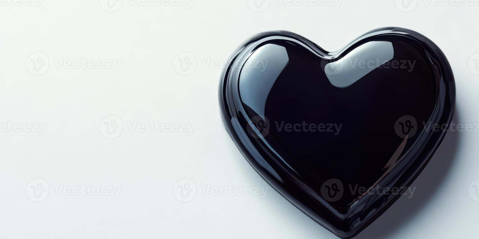 Dark glossy heart shape resting on a light surface creating a contrast in colors and textures photo
