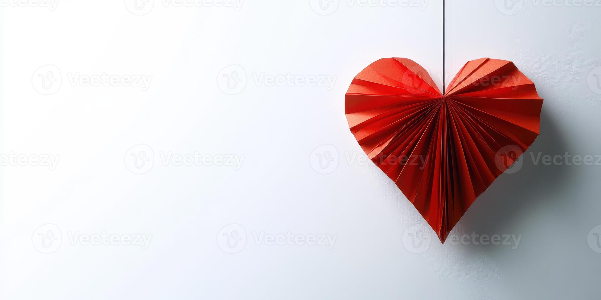 Hanging red heart decoration crafted from paper against a minimalist white background photo