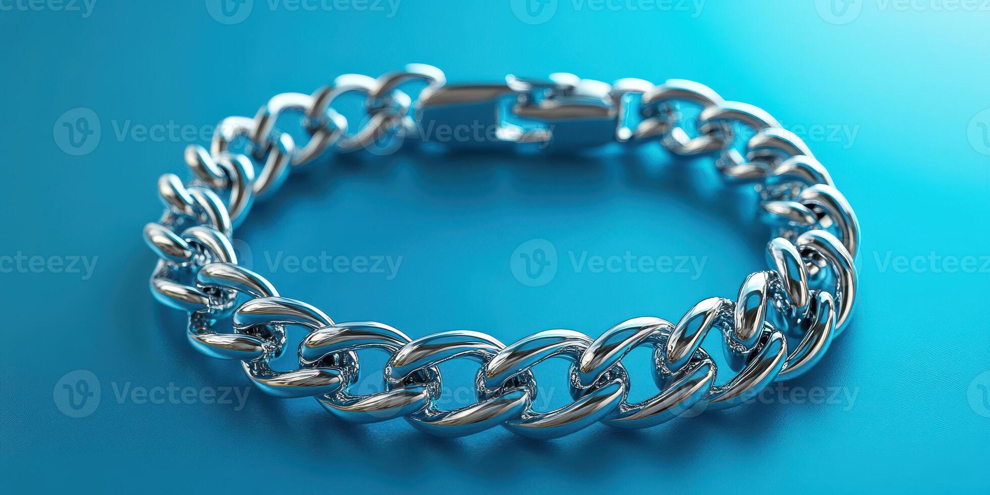 Silver chain bracelet resting on a blue surface showcasing its shiny and intricate link design photo