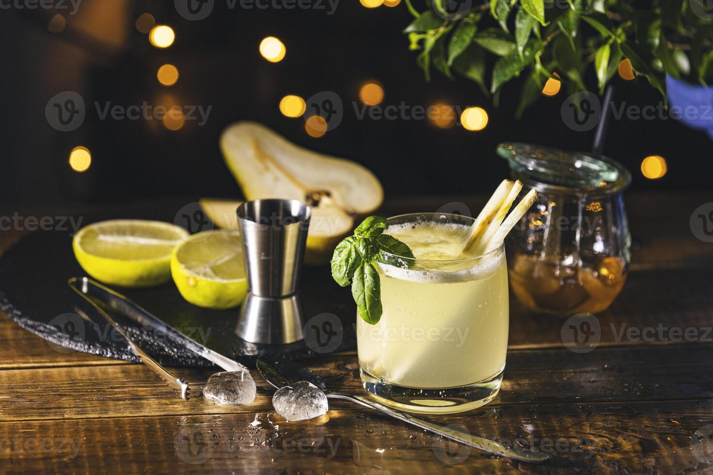 Bartender preparing delicious cocktail with pear, lime, and honey on wooden table photo