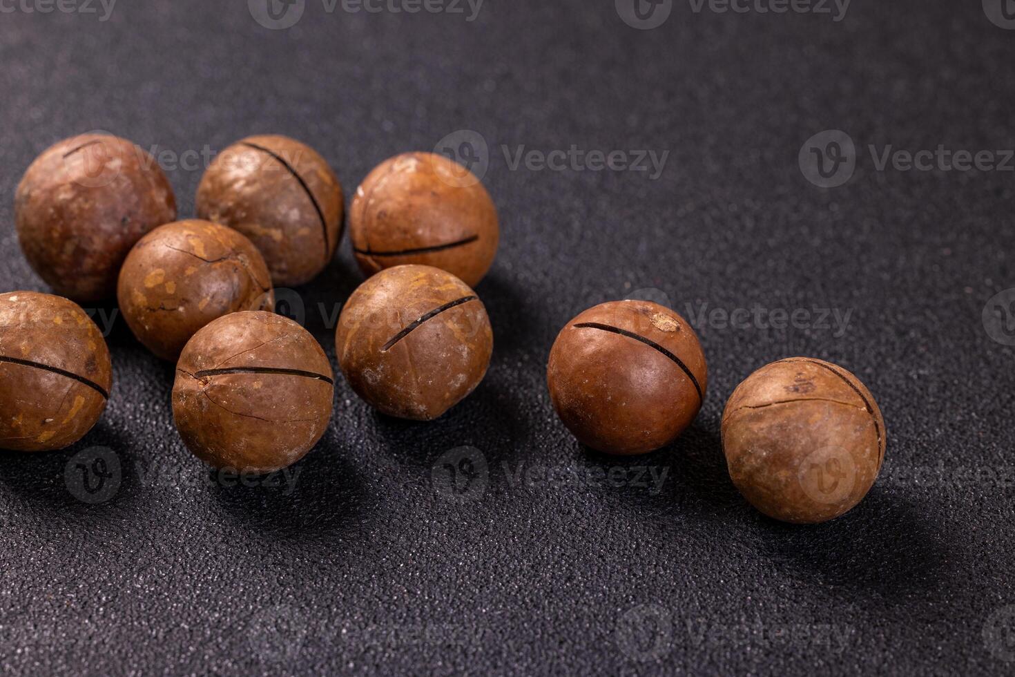 Macadamia nuts displayed on a dark background, ready for snacking photo