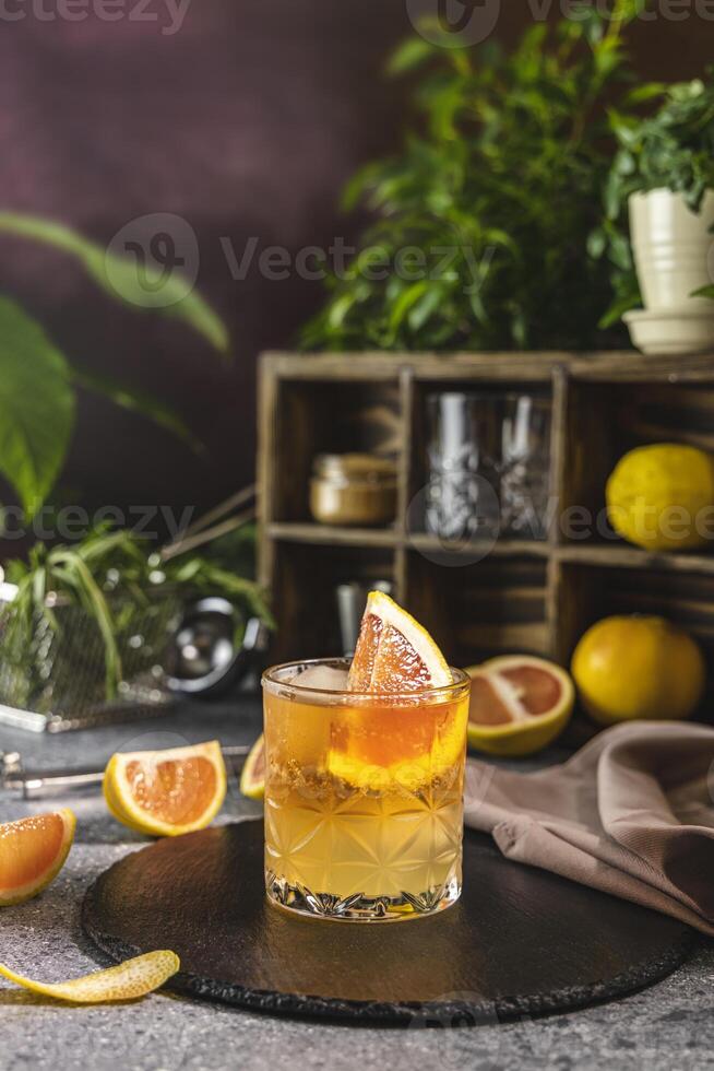 Refreshing cocktail with grapefruit slice and ice cubes on bar counter photo