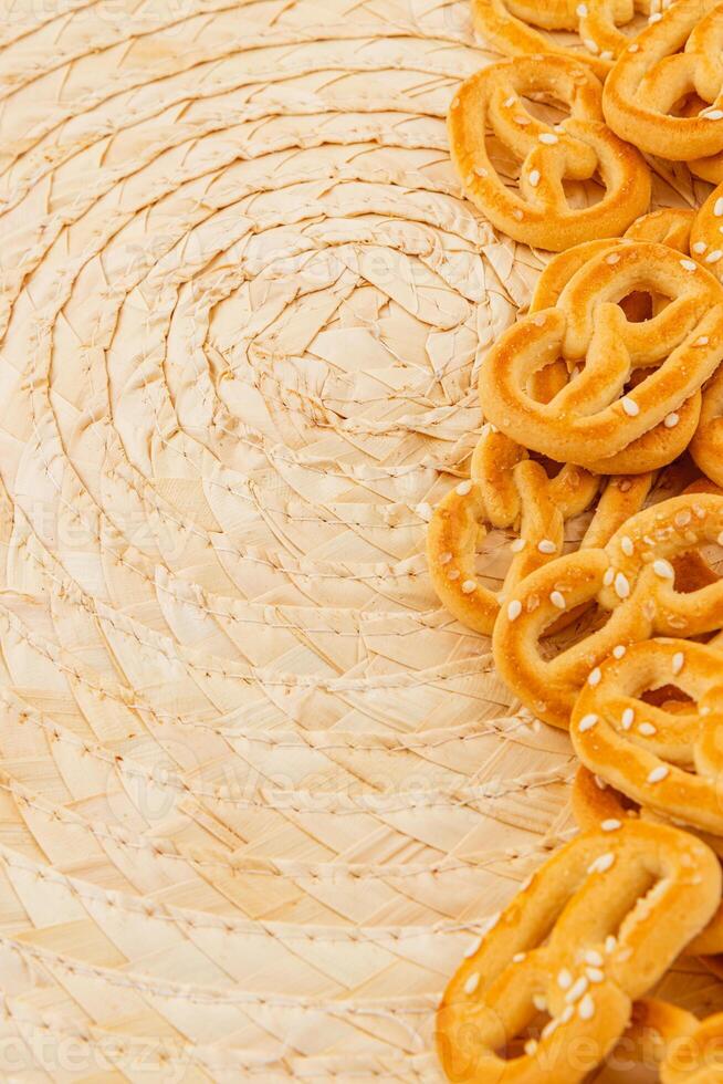 Enjoying fresh sesame pretzels on a rustic woven mat in the afternoon photo