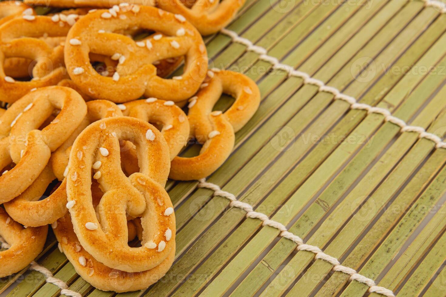 Freshly baked pretzels on a bamboo mat with a touch of sesame seeds photo