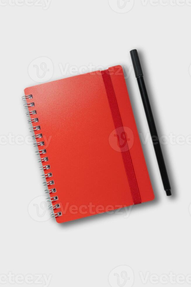 red notebook with pencil. school notebook on white background, spiral notepad on table photo