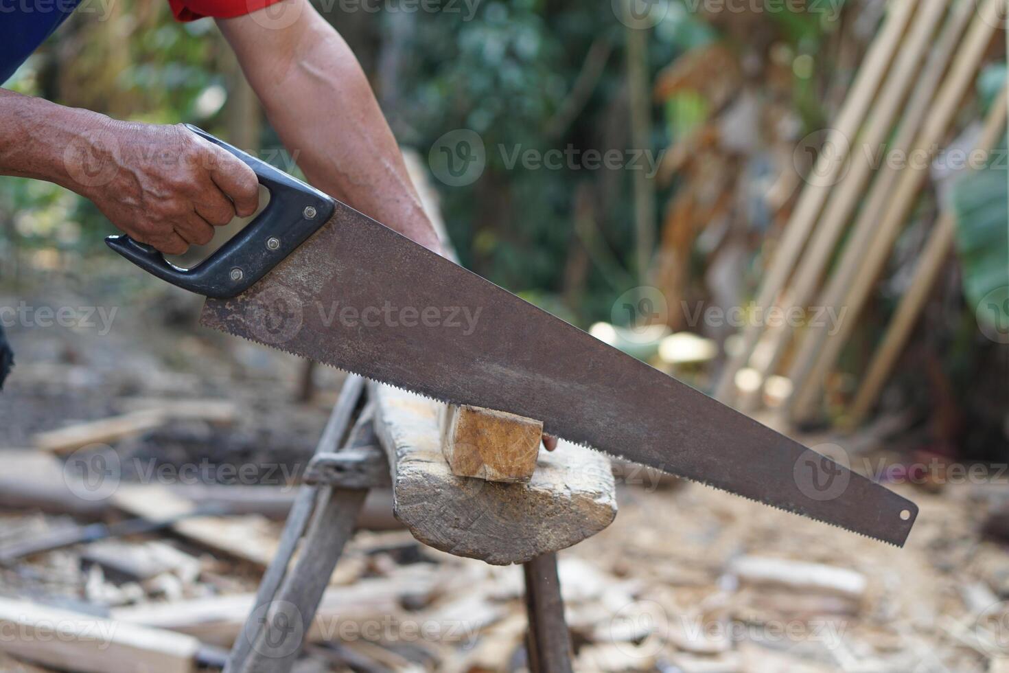 Carpenter hand is cutting wood by saw. Concept, tool for cutting. Carpentry , woodwork and construction work tool. Carpentry. use for cutting wood. Handsaw for carpenter. photo