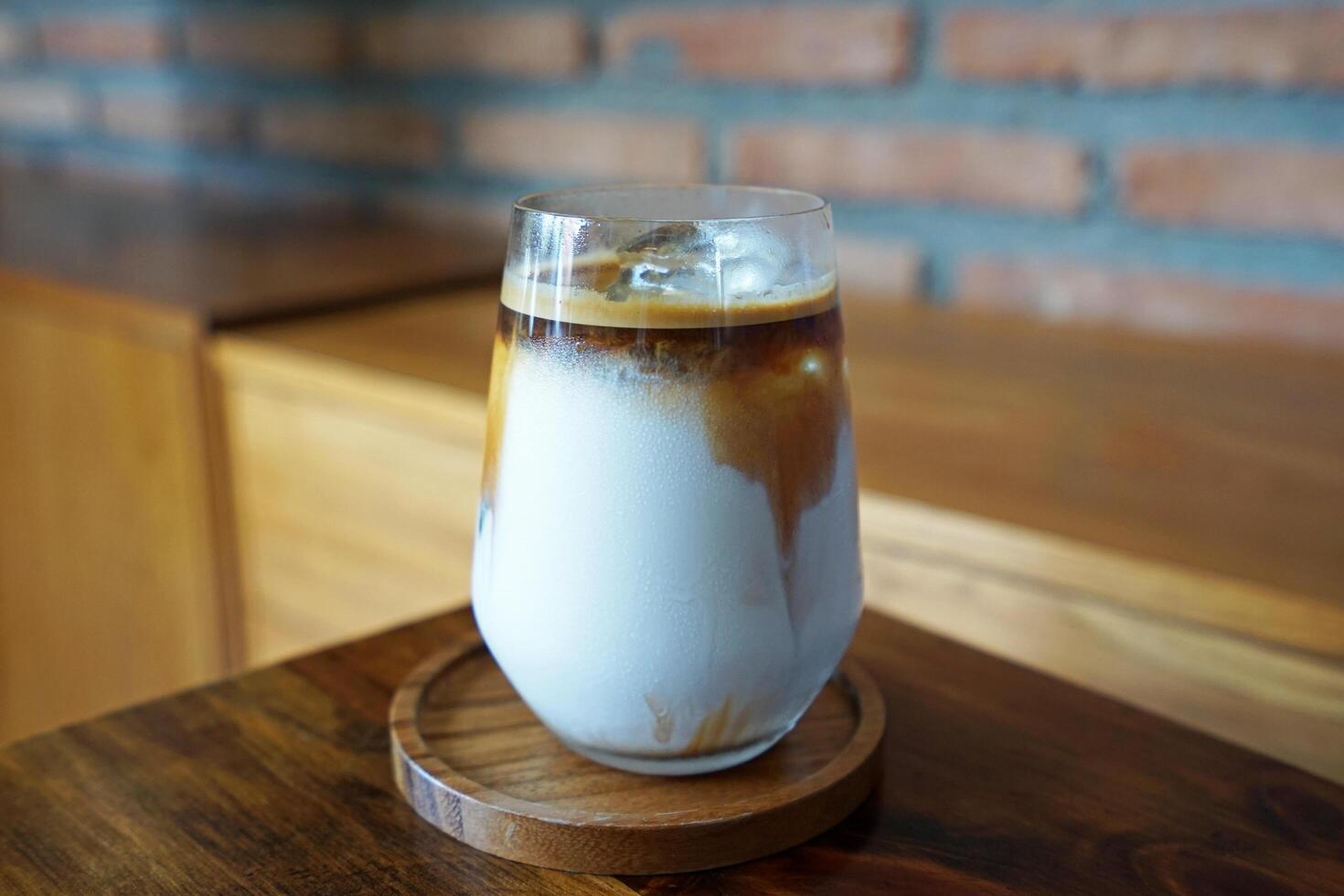 Close up glass of iced dirty Latte coffee on wooden tray table photo