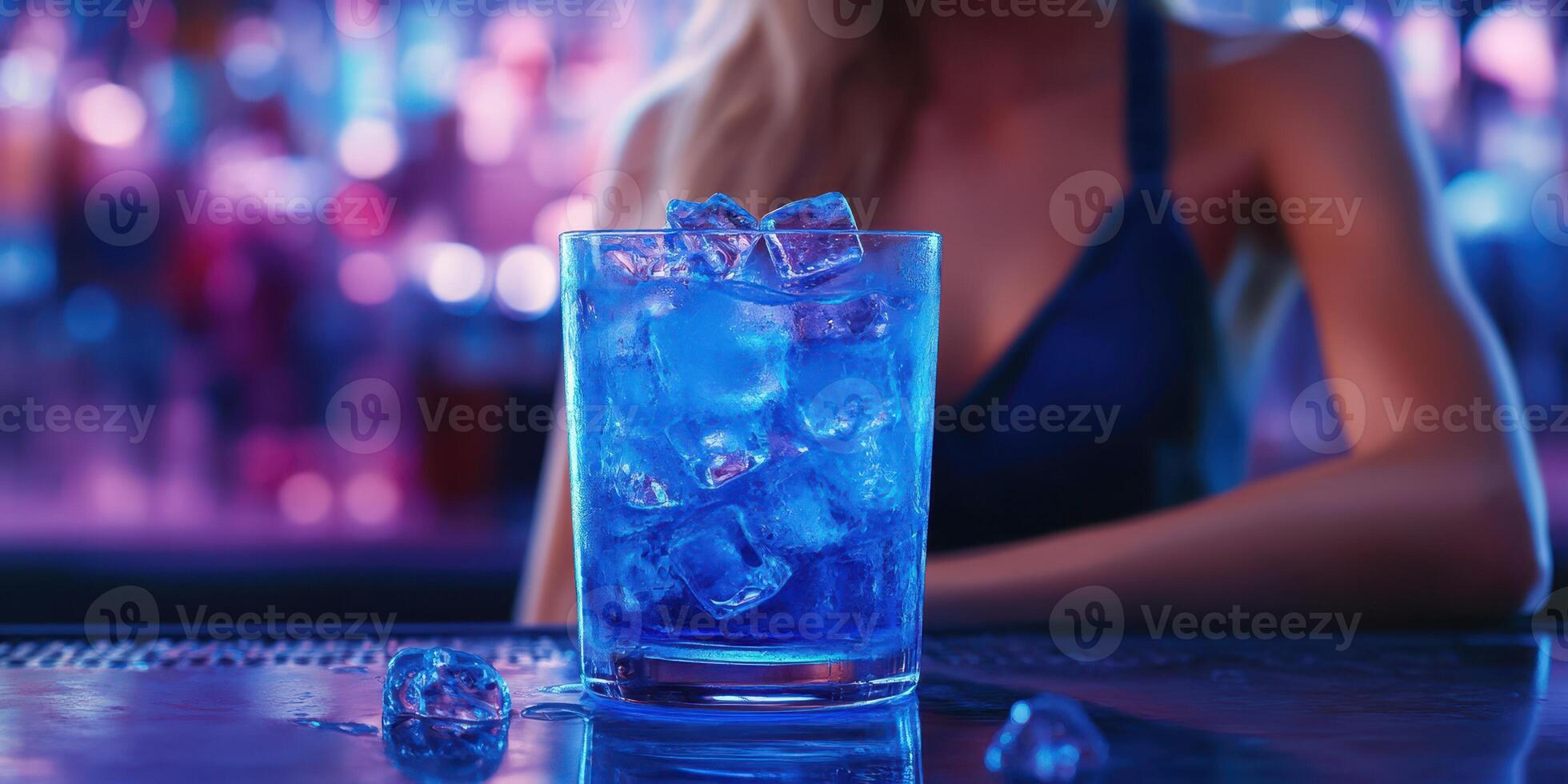 Vibrant blue cocktail served in a glass with ice in a lively bar setting at night photo