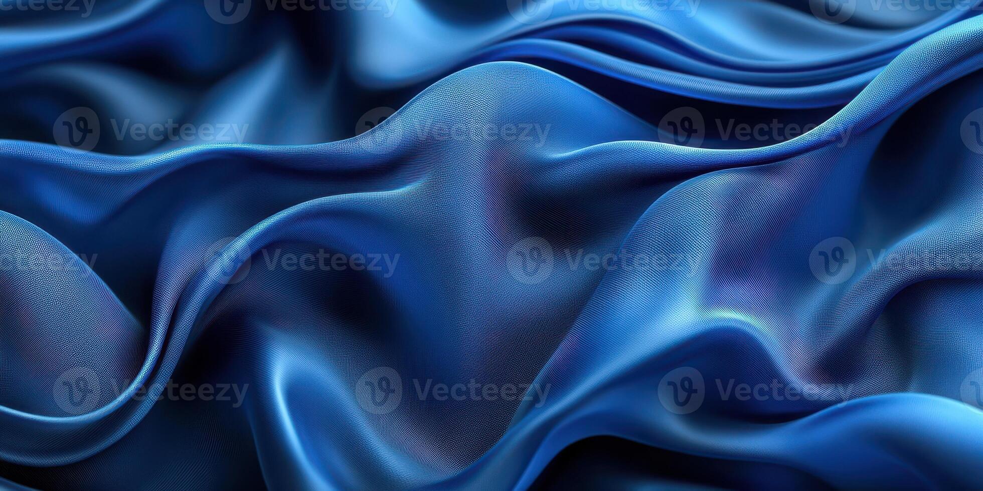 Deep blue silk fabric draped elegantly creating soft waves and textures under gentle lighting photo