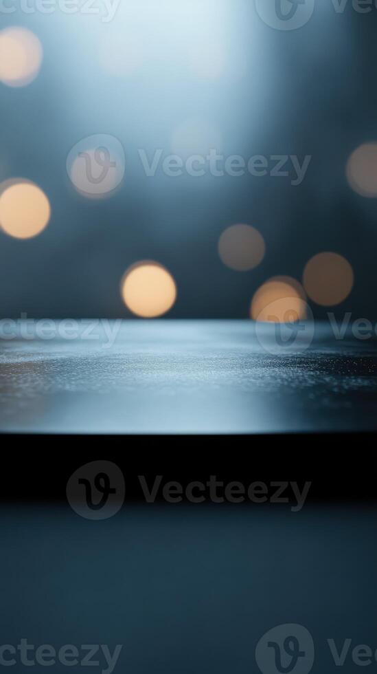 Soft light illuminating a reflective surface with blurred bokeh against a dark background at nighttime photo