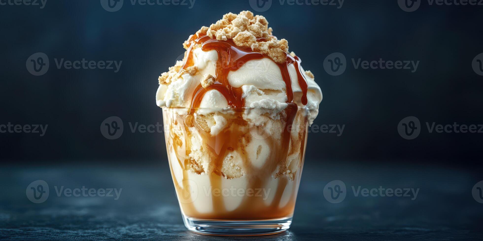 Delicious dessert featuring creamy ice cream topped with caramel and crushed cookies captured in a dimly lit setting photo