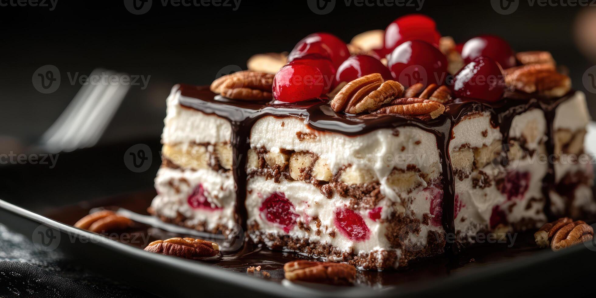 Rich chocolate layered dessert topped with cherries and pecans served on a black plate photo