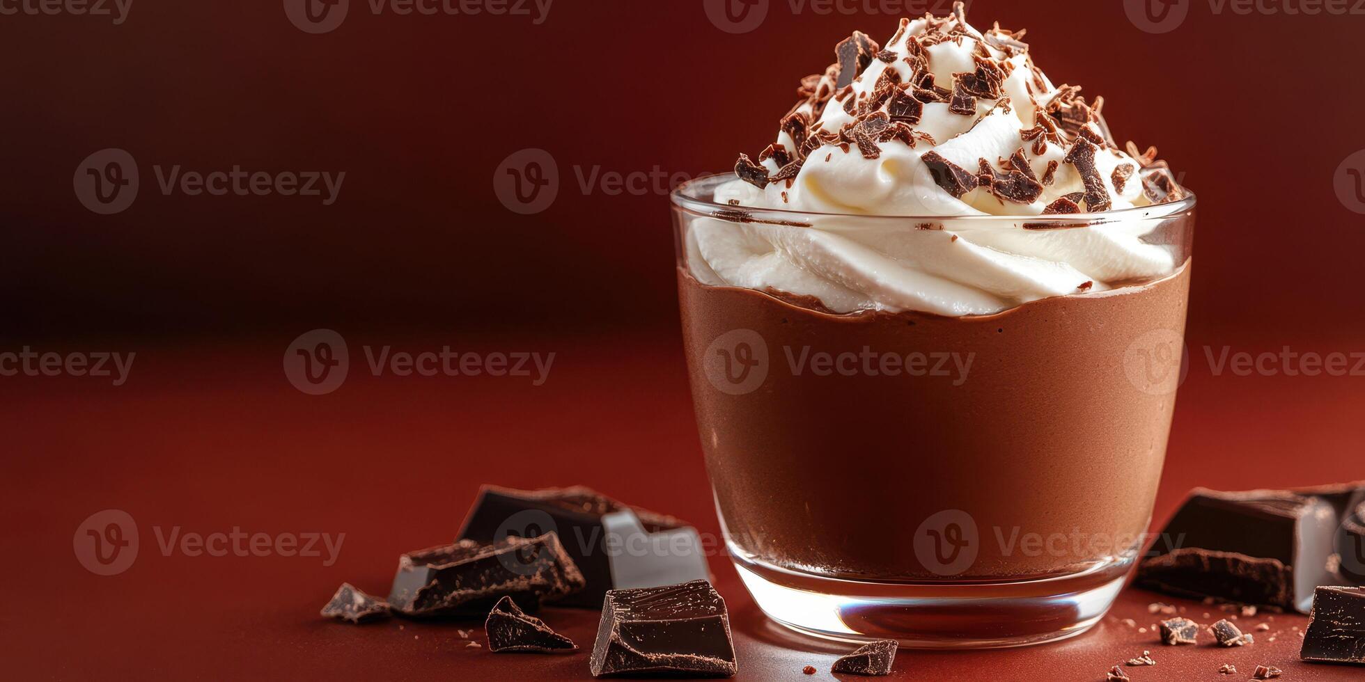 Decadent chocolate mousse dessert topped with whipped cream and shavings served in a glass on a wooden surface photo