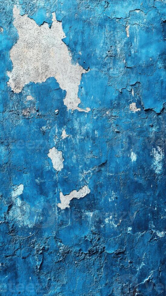 Textured blue wall with peeling paint revealing layers underneath in an urban setting photo