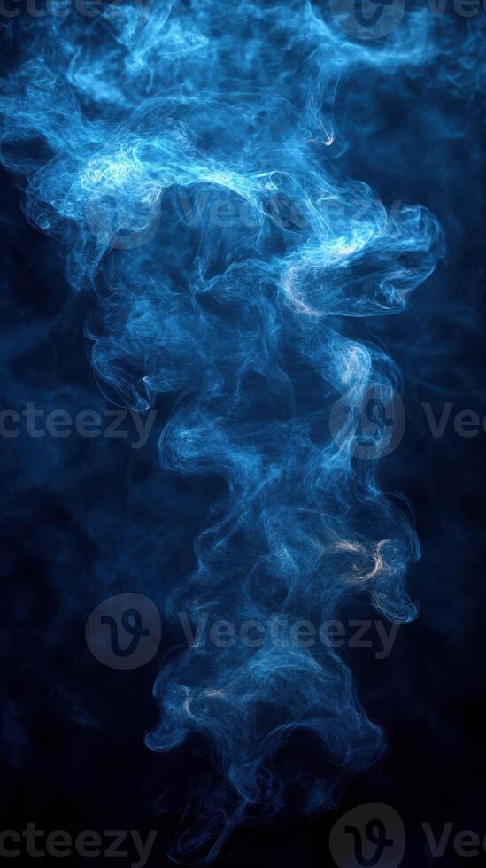 Swirling blue smoke creates a mystical atmosphere in a dark background illuminated with soft light photo