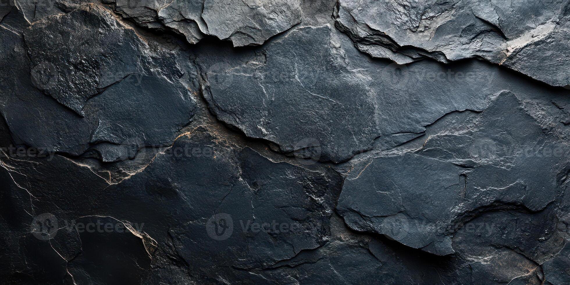 Dark textured rock surface showcasing natural geological patterns and shadows in a dimly lit environment photo
