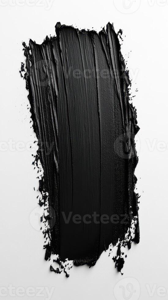 Black paint applied in abstract strokes, creating a textured and artistic finish on a white background photo